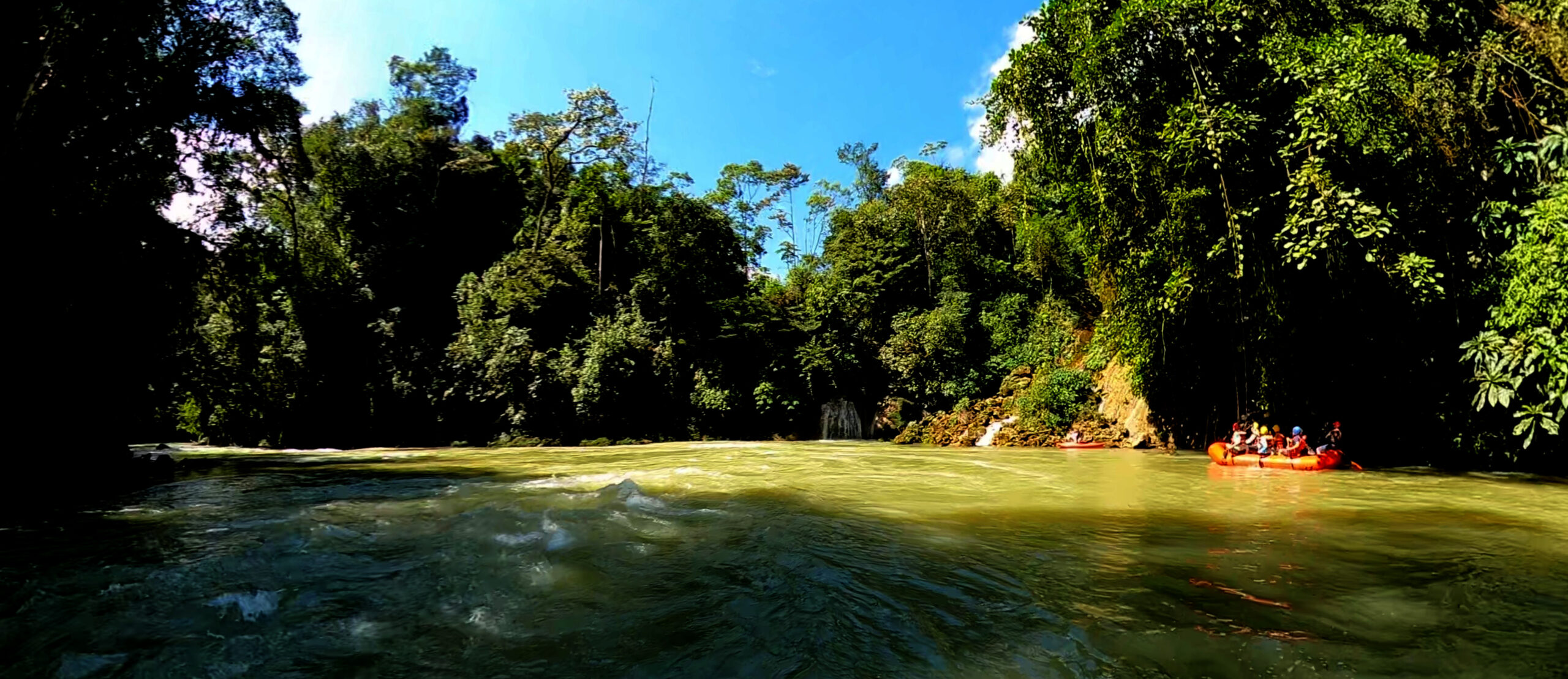 river with a rafting boat and waterfall